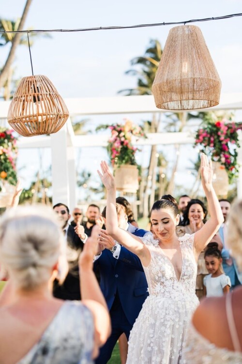Matias Ezcurra Photography, Bride and groom joyfully dance at their Andaz Maui wedding reception, surrounded by celebrating guests.